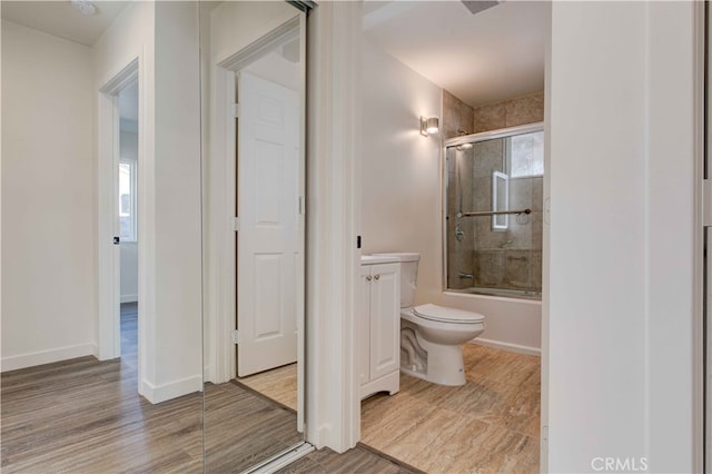 full bathroom with vanity, combined bath / shower with glass door, hardwood / wood-style floors, and toilet