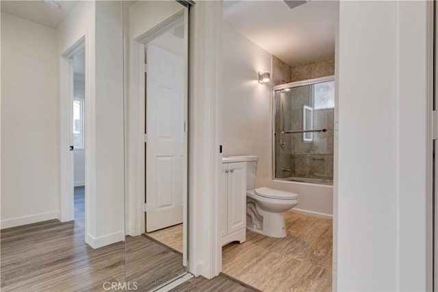 8812 Laurel Canyon Blvd, Sun Valley, CA 91352 - full bathroom featuring toilet, enclosed tub / shower combo, vanity, wood finished floors, and baseboards
