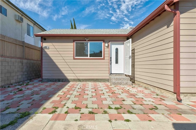 exterior space with a patio and a wall unit AC