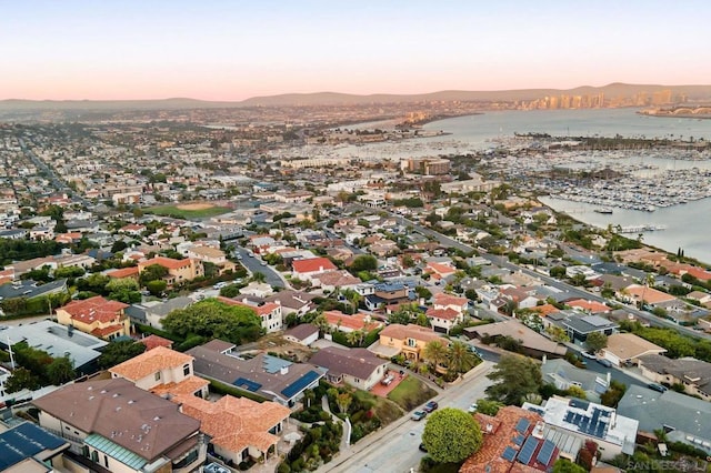 aerial view at dusk featuring a water view