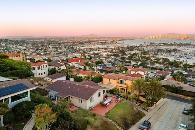 aerial view at dusk featuring a water view