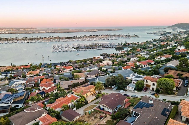 aerial view at dusk featuring a water view