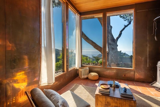 sunroom featuring a mountain view and wooden ceiling