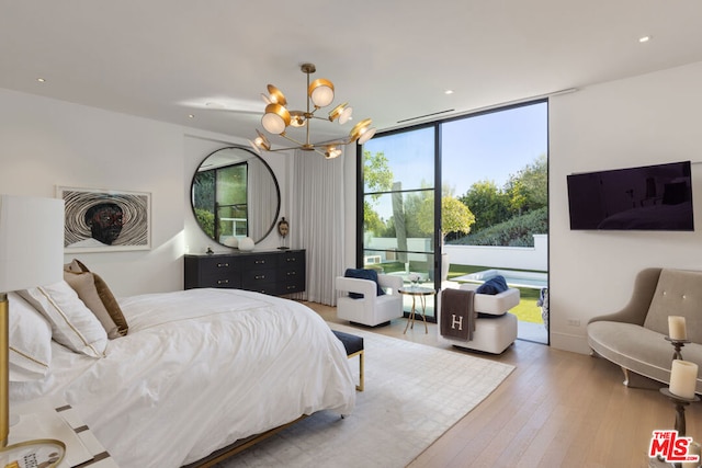 bedroom with access to exterior, light hardwood / wood-style flooring, and a chandelier