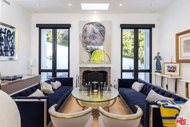 living room with french doors, plenty of natural light, and a high end fireplace