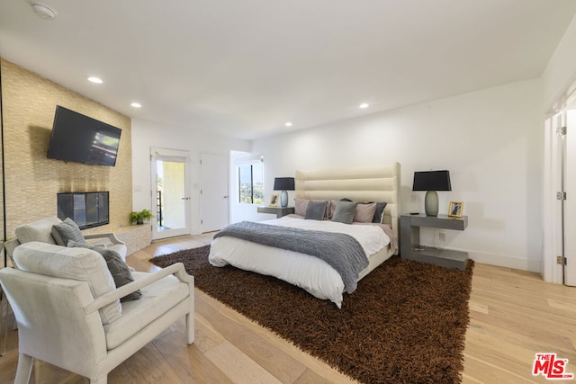 bedroom featuring light hardwood / wood-style flooring and a fireplace