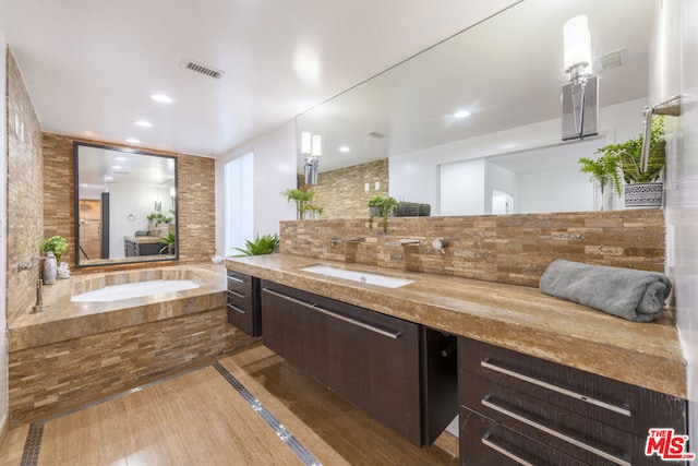 bathroom featuring decorative backsplash, vanity, and a bathtub