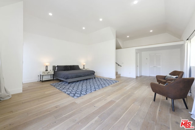 bedroom with lofted ceiling and light hardwood / wood-style floors