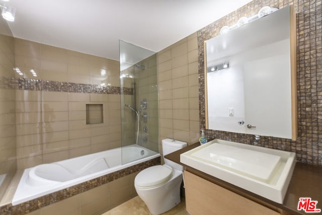 full bathroom featuring tile walls, vanity, and toilet