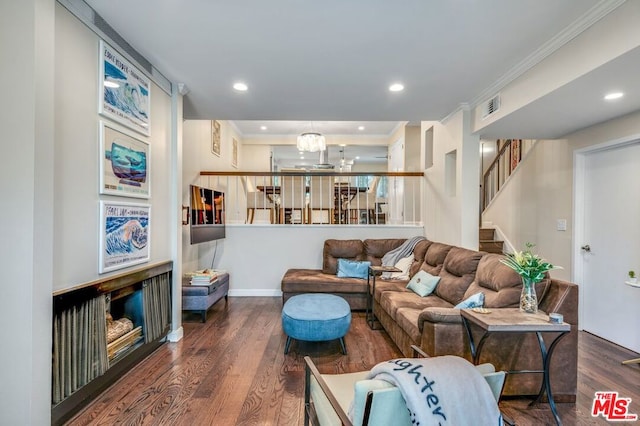 living room featuring an inviting chandelier, dark hardwood / wood-style floors, and ornamental molding