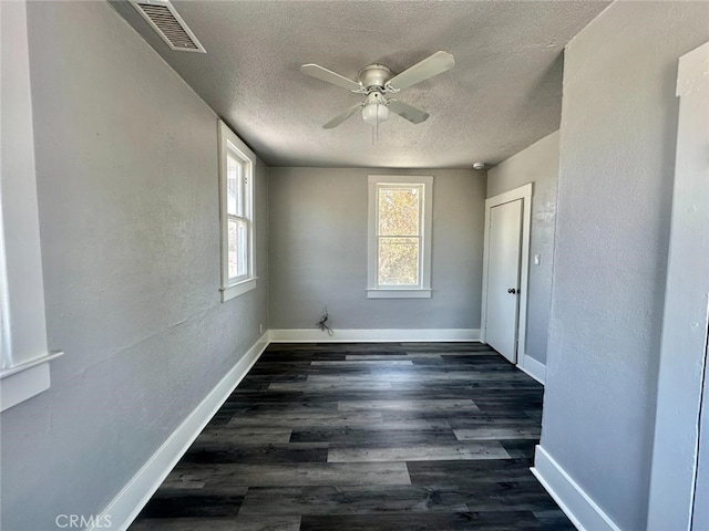 unfurnished room featuring a textured ceiling, dark hardwood / wood-style floors, and ceiling fan