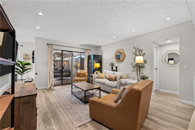 living room with a textured ceiling and light hardwood / wood-style floors