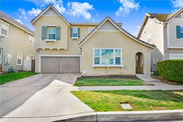 view of front of house with stucco siding, a front yard, a garage, and driveway