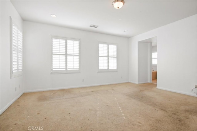 carpeted spare room featuring plenty of natural light