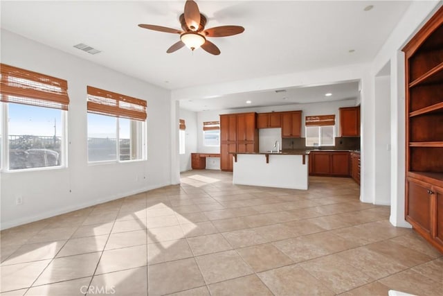 interior space with ceiling fan, light tile patterned flooring, and sink