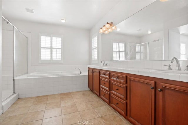 bathroom with independent shower and bath, tile patterned flooring, vanity, and a healthy amount of sunlight