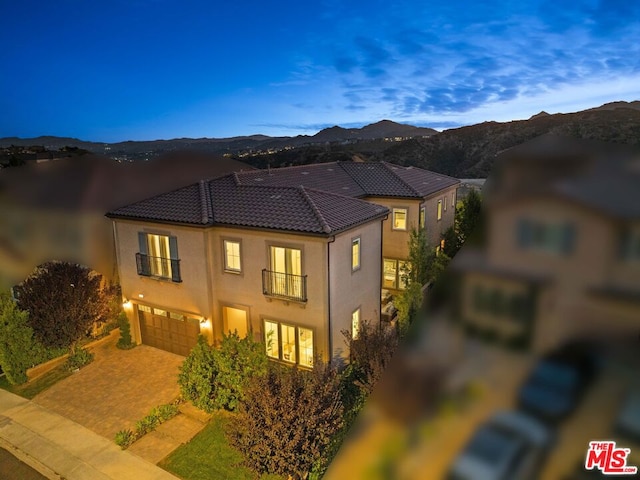 view of front of property with a mountain view, a balcony, and a garage