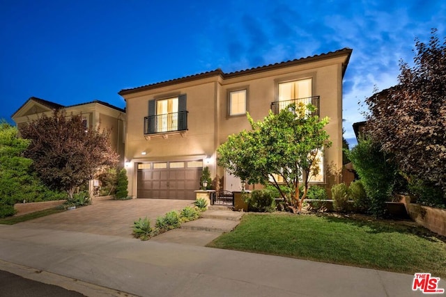 mediterranean / spanish-style house with a garage and a balcony