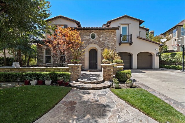 mediterranean / spanish-style home featuring a garage, a balcony, and a front yard