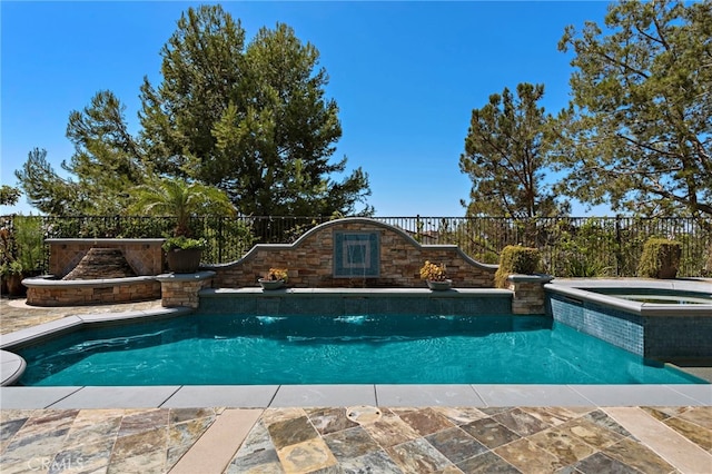 view of swimming pool with an in ground hot tub, pool water feature, and a patio area