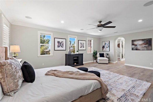 bedroom with ceiling fan, crown molding, and light hardwood / wood-style floors