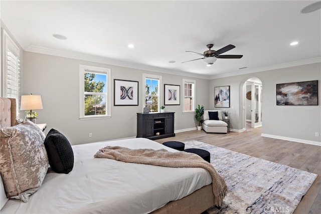 bedroom featuring ornamental molding, ceiling fan, and light hardwood / wood-style flooring