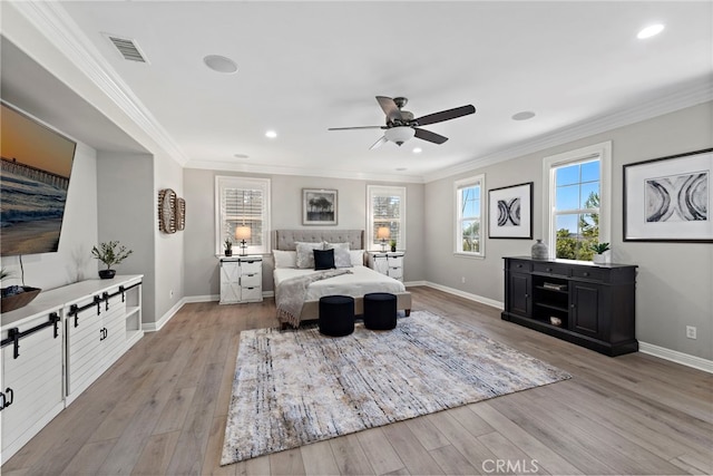 bedroom with crown molding, light hardwood / wood-style floors, and ceiling fan