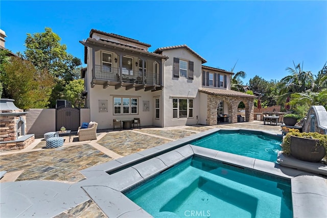 back of house featuring a fenced in pool, a patio, and a balcony