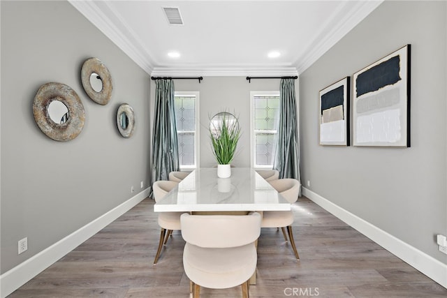 dining space with wood-type flooring and crown molding