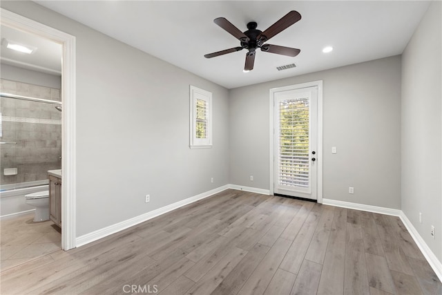 unfurnished bedroom with ceiling fan, ensuite bathroom, access to outside, and light wood-type flooring