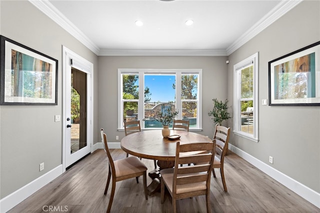 dining area with light hardwood / wood-style floors and crown molding