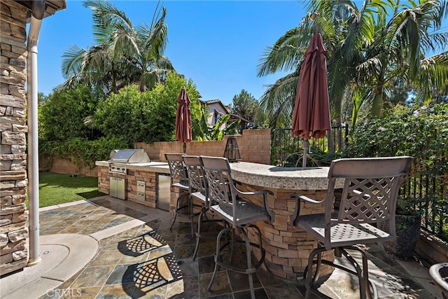 view of patio with area for grilling and an outdoor bar