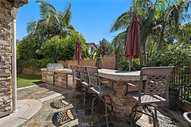 view of patio / terrace with a grill, exterior bar, and exterior kitchen