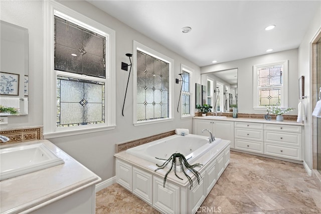 bathroom featuring plenty of natural light, a bathtub, and vanity