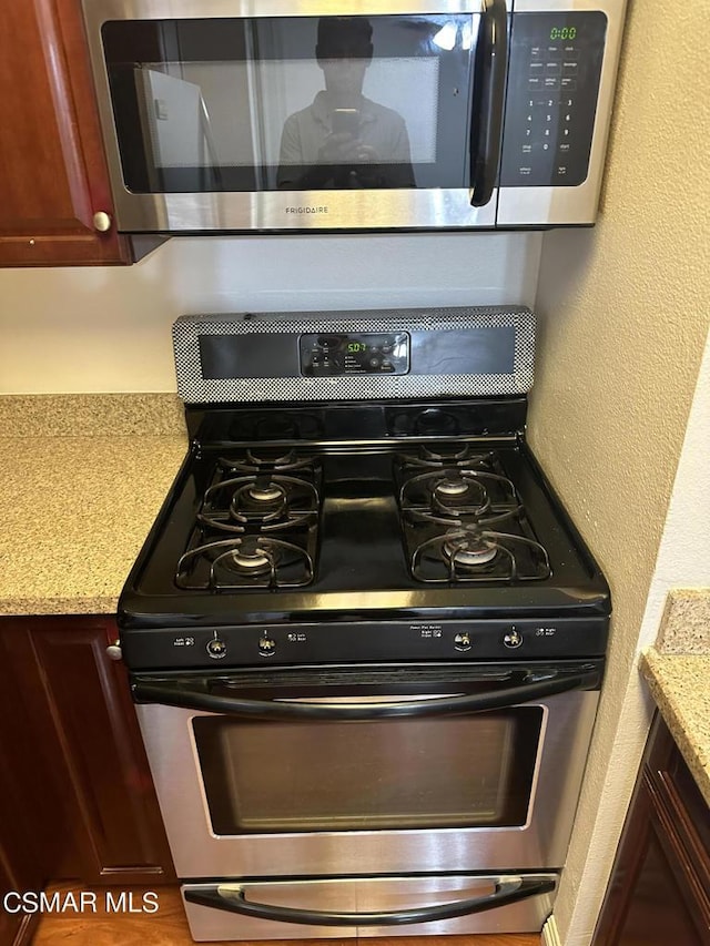 kitchen with light stone countertops and appliances with stainless steel finishes