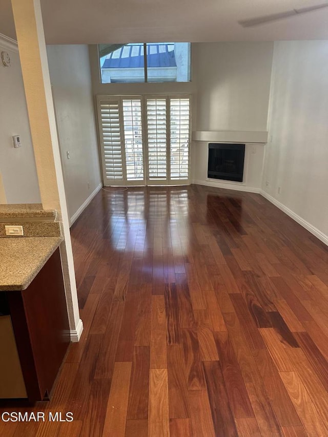 unfurnished living room with dark hardwood / wood-style floors