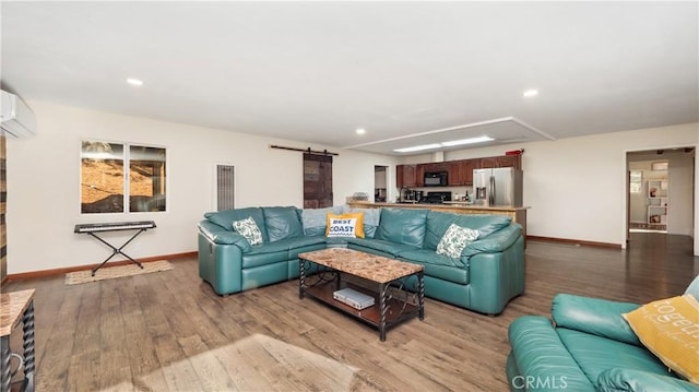 living room featuring a wall unit AC, a barn door, and light hardwood / wood-style flooring