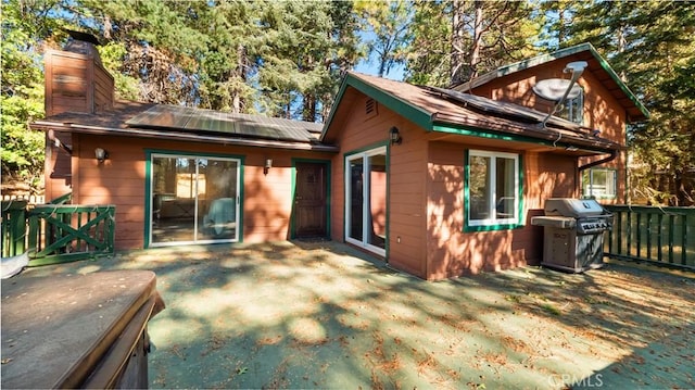 back of house with solar panels and a patio