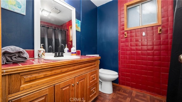 bathroom with parquet flooring, vanity, and toilet