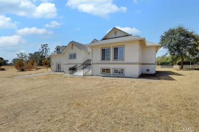 rear view of property with a lawn