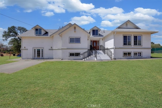 view of front facade with a front yard and french doors