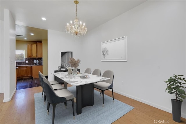 dining space featuring a notable chandelier and light wood-type flooring