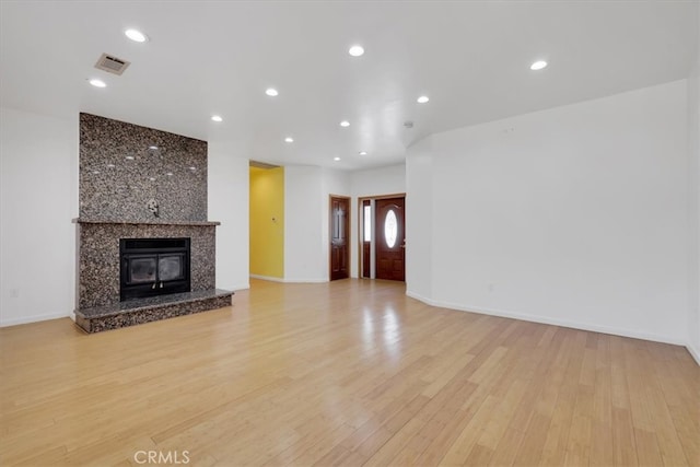 unfurnished living room with light wood-type flooring and a fireplace