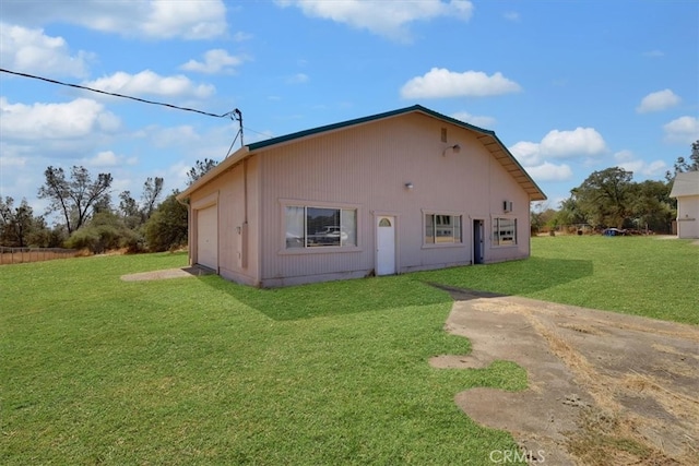 rear view of house with a lawn and a garage