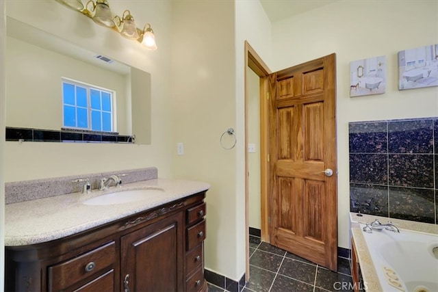 bathroom with tile patterned flooring, tiled bath, and vanity