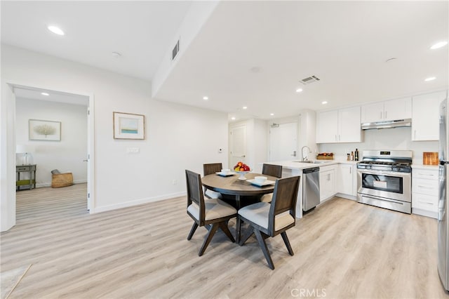 dining area with light wood-type flooring and sink