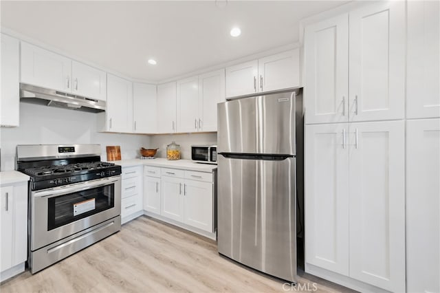 kitchen with appliances with stainless steel finishes, light wood-type flooring, and white cabinetry