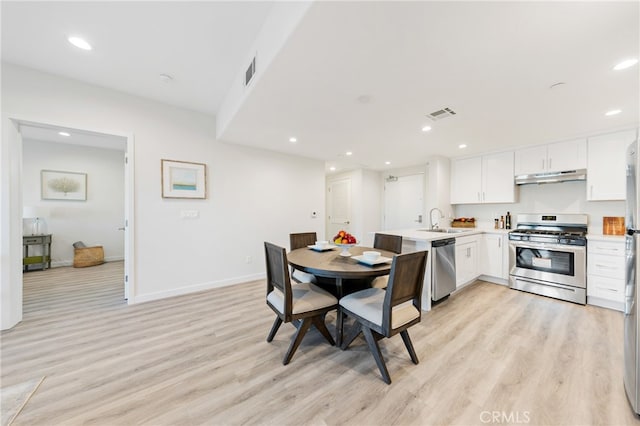 dining space featuring light hardwood / wood-style floors and sink