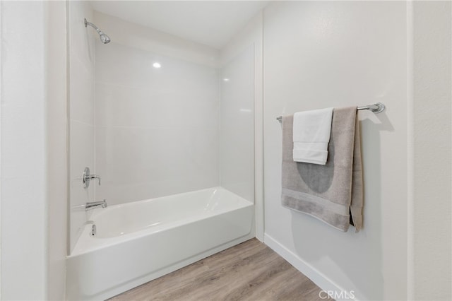 bathroom featuring washtub / shower combination and wood-type flooring