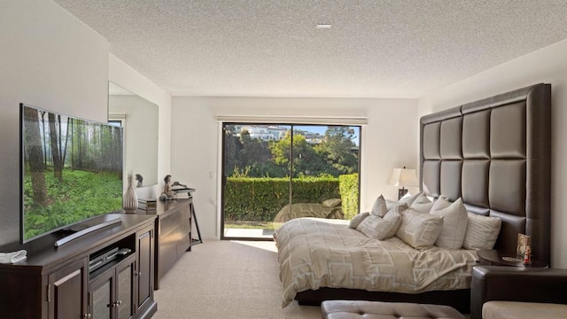 carpeted bedroom featuring access to outside and a textured ceiling